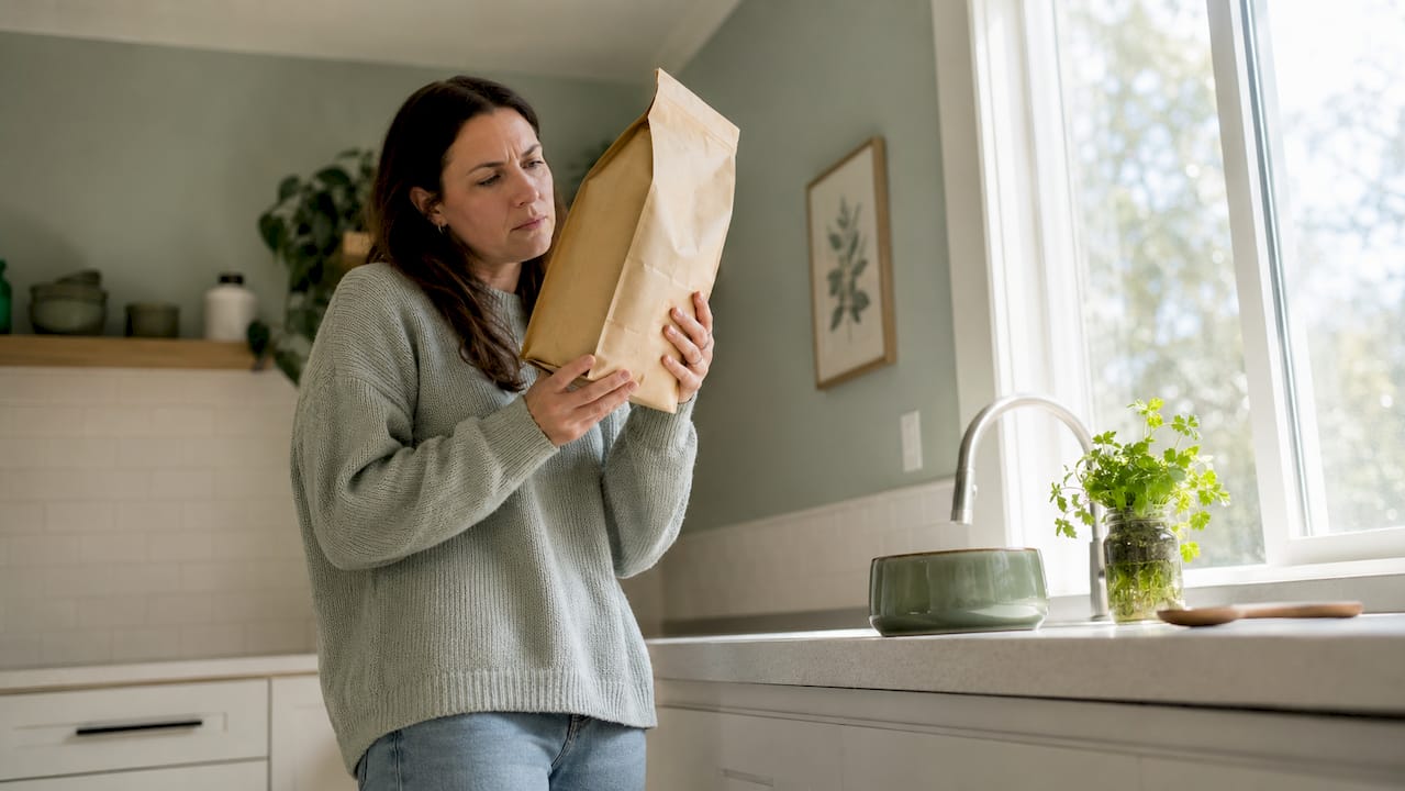 Woman reading dog food ingredient label